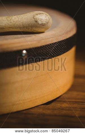 Traditional Irish bodhran and stick on wooden table