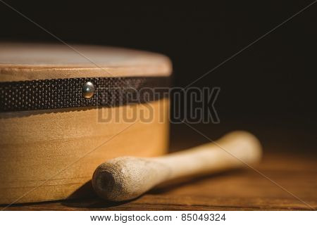 Traditional Irish bodhran and stick on wooden table