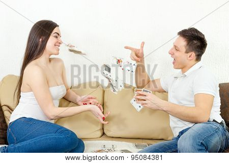 Smiling Couple Throwing Cards At Each Other