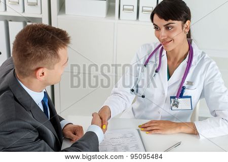 Beautiful Smiling Female Medicine Doctor Shaking Hands With Male Patient