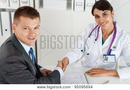 Beautiful Smiling Female Medicine Doctor Shaking Hands With Male Patient