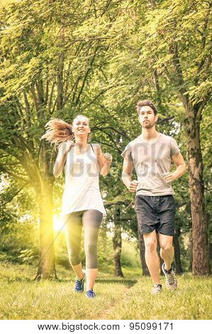 Happy Couple Jogging In The Park - Young Man And Woman Sharing Workout And Sport Activity