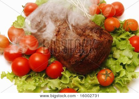체리 토마토와 함께 큰 뜨거운 연기 고기 덩어리