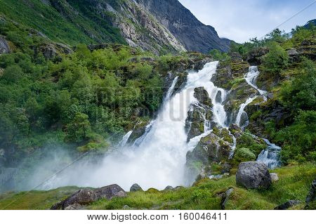 Briksdalsbreen waterfall. Norway national park and popular hiking path to glacier viewpoint.
