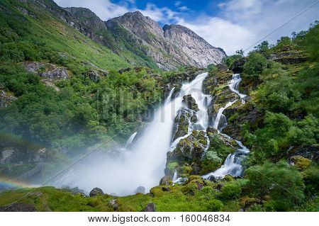 Briksdalsbreen waterfall long exposure photo. Briksdal, Norway national park and popular hiking path to glacier viewpoint.