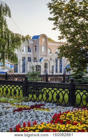District center Stroitel in Belgorod region. Flowerbed. View of fragment facade of the house culture and celebrations, registry office. Provincial administration building with clockwork mechanism.