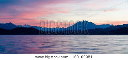 Romantic sunset over the lake in the Swiss Alps. Canton Zug. In the background the mountains silhouettes. High Dynamic Range Image