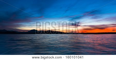 Dramatic sunset over the lake in the Swiss Alps. Canton Zug. In the background the mountains silhouettes. High Dynamic Range Image