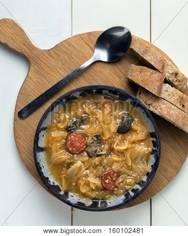 Christmas cabbage soup on white wooden background.