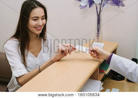 Beautiful woman at the doctor. Receptionist. The secretary writes the patient's appointment.