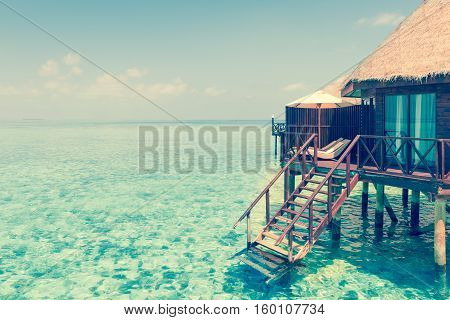 Panorama of tropical island resort with overwater bungalows at night. Maldives. Ari Atoll.