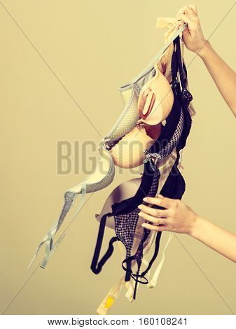 Female Hand With Many Bras To Wear