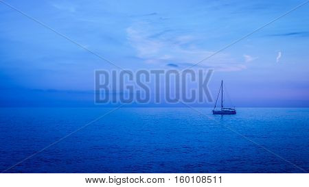 Sea surface is painted in ultramarine and blue colors sunset. Clear skie with some clouds.