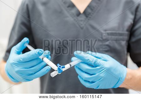 The Doctor hand with medical syringe close-up device