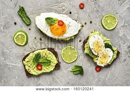 Assortment Of Avocado Toasts On A Concrete Or Slate Background.top View.