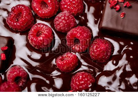Candies and raspberry in hot chocolate background. From above.