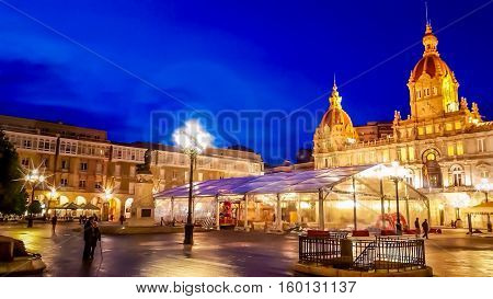 Night cityscape of Coruña, Galicia, Spain. Illuminated Municipal Palace and City Hall Square of Coruna at blue evening hour