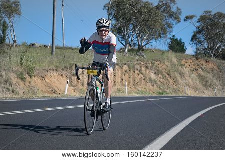 Jindabyne, Snowy Mountains Region, Australia - December 3, 2016: The first L'Etape cycling event held in Australia (by Le Tour de France).  Cyclist smiles and waves were common in the 2nd race stage.