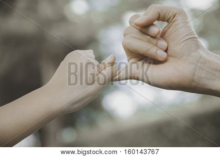mother and her child hooking their fingers to make a promise vintage style