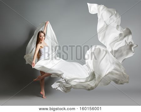 Beautiful Young Girl Dancing. The Girl In Flying White Dress. A White Cloth Is Flying In The Air. Wh