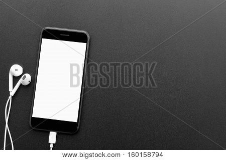 black phone and headphones on table top view with copyspace