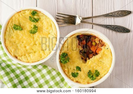 Shepherd pie on white wooden background .