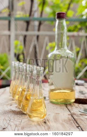 Bottle Of Plum Brandy With Small Glasses On Wooden Table