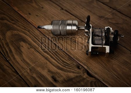 Tattoo Gun On A Rustic Wooden Table