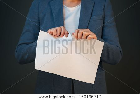 Unsatisfied and angry businesswoman tearing business legal agreement contract paper