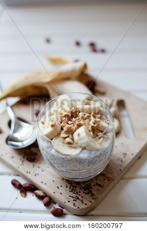 Banana chia yogurt pudding decorated with ripe sliced banana and peanuts