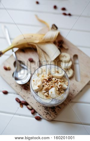 Banana chia yogurt pudding decorated with ripe sliced banana and peanuts