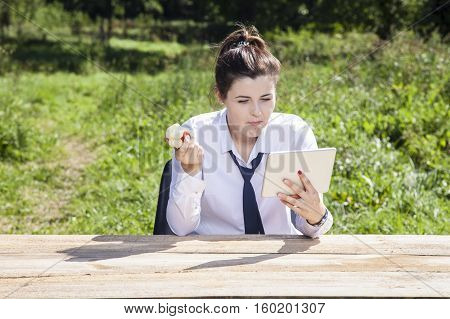 Focused Business Woman Eating An Apple And Reading Messages