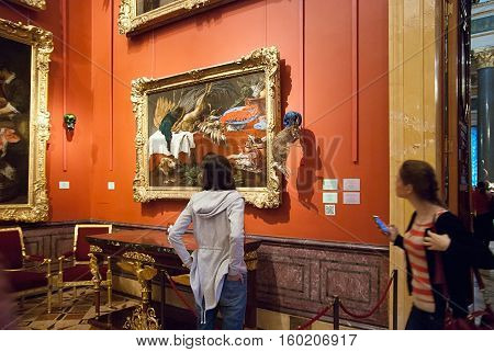 Saint-Petersburg, Russia, December 1, 2016: People look at the stuffed rabbit with scull near painting in The State Hermitage Museum. Exhibit of temporary modern art exhibition 