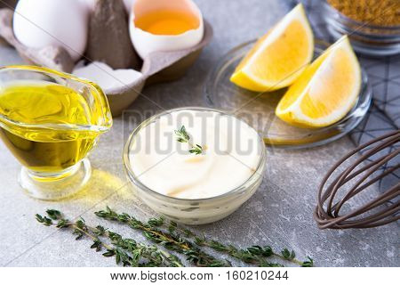 Fresh Homemade White Sauce Mayonnaise And Ingredients Eggs, Lemon Olive Oil On Stone Background.