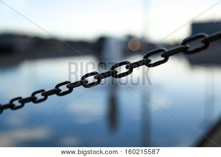 Iron chain detail city in the background selective focus taken in Copenhagen Denmark