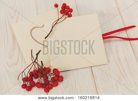 Empty envelopes with red rowan and stripe.White wooden table.Empty space for text