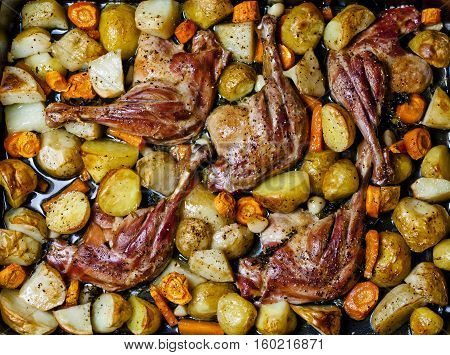 Baked duck legs with vegetables and potherbs