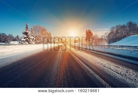Asphalt road in snowy winter on beautiful frosty sunny day