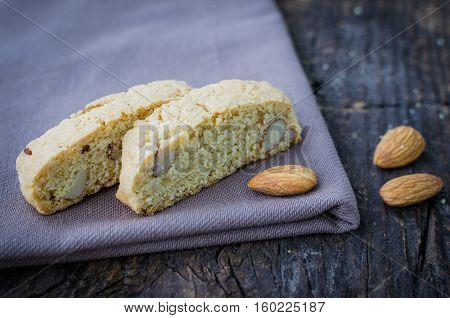 Italian cantuccini cookies with almond. Traditional italian almond cookies biscotti on old wooden background. Homemade Almond cookies on wooden table. Delicious cookies biscotti. Selective focus.
