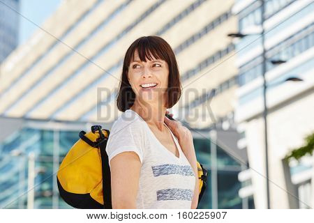 Smiling Older Traveler Carrying Duffel Bag In City