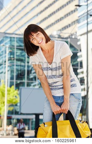 Older Traveler Carrying Heavy Duffel Bag Outside