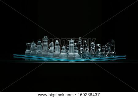Corner view of transparent glass chess board on black backround