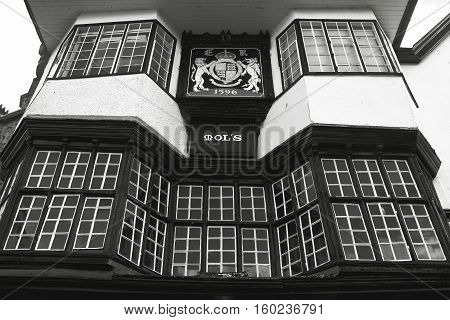 EXETER UK 11 July 2016: Facade of an ancient building in the center of Exeter. Mol`s House 1596. The coat of arms of the city. Black and white photography. Devon. England