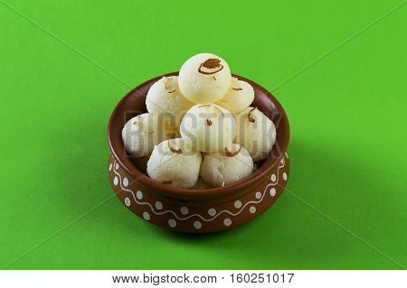 Indian Sweet or Dessert - Rasgulla, Famous Bengali sweet in clay bowl on green background