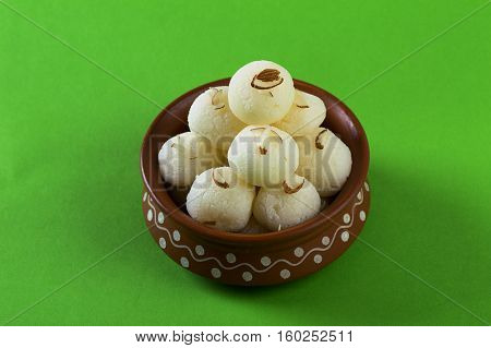 Indian Sweet or Dessert - Rasgulla, Famous Bengali sweet in clay bowl on green background