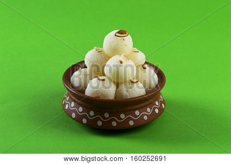 Indian Sweet or Dessert - Rasgulla, Famous Bengali sweet in clay bowl on green background