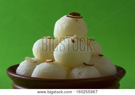 Indian Sweet or Dessert - Rasgulla, Famous Bengali sweet in clay bowl on green background
