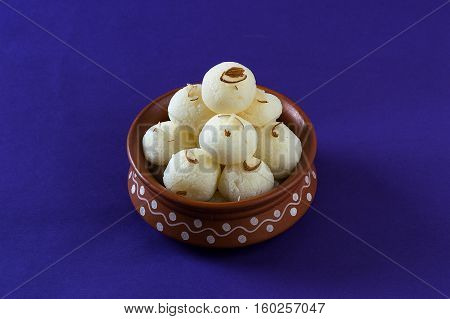 Indian Sweet or Dessert - Rasgulla, Famous Bengali sweet in clay bowl on blue background