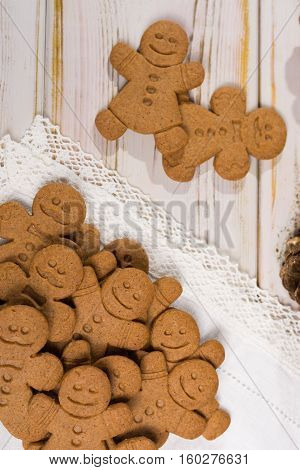 Christmas smiling gingerbread men men and women on white handmade lace with Christmas decoration