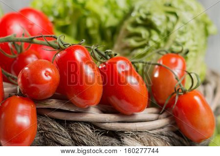 Ingredients for fresh spring healthy green salad. Green fresh roma lettuce salad leaves and roma mini tomatoes - healthy low calorie food
